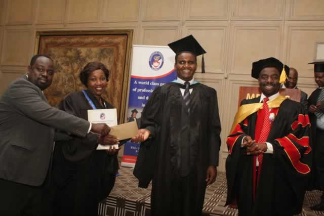 National University of Science and Technology acting dean of commerce Mr Takaivona Vhimisai (second right) hands over an envelope containing the prize money for best overall student in short term insurance business to Mrs Nellia Matarutse and her husband Oliver during the Insurance Institute of Zimbabwe graduation ceremony on Friday while IIZ president Mr Chomi Makina (right) looks on