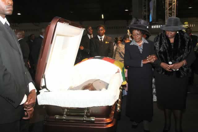 Out-going Minister of Small to Medium Enterprises and Cooperatives, Cde Sithembiso Nyoni (left) and the late national hero, Cde Enos Nkala’s wife Thandiwe Nkala, pay their last respects at the ZITF grounds in Bulawayo yesterday