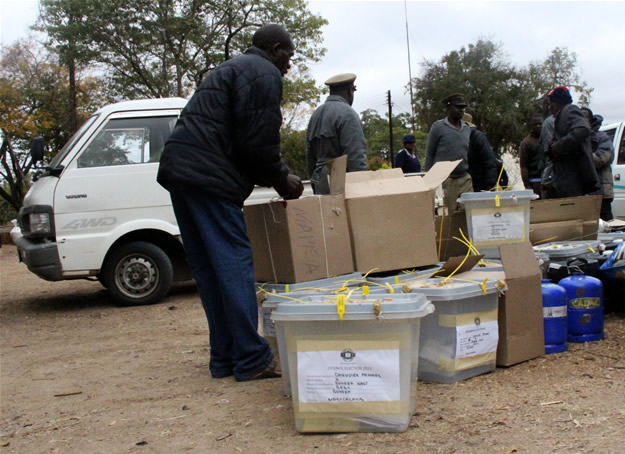 Officials and a plocice officer arrive at Buhera West command center with ballot boxes and other materials used during elections.