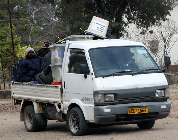 Officials and a plocice officer arrive at Buhera West command center with ballot boxes and other materials used during elections.