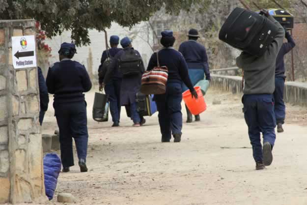 Officials and a plocice officer arrive at Buhera West command center with ballot boxes and other materials used during elections.