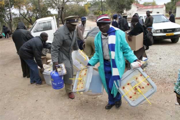 Officials and a plocice officer arrive at Buhera West command center with ballot boxes and other materials used during elections.