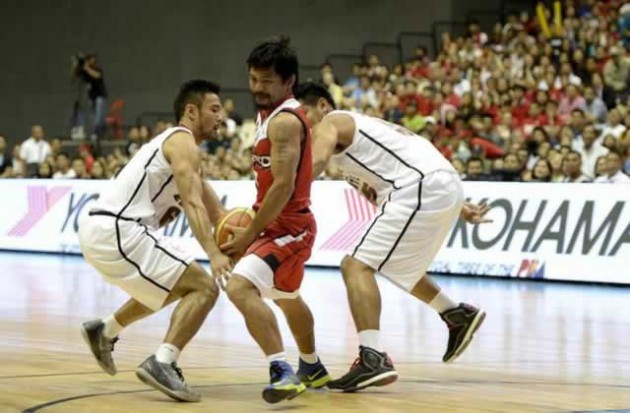 World boxing champion Manny Pacquiao (centre) plays for and coaches the Kia Carnival basketball team. — AFP