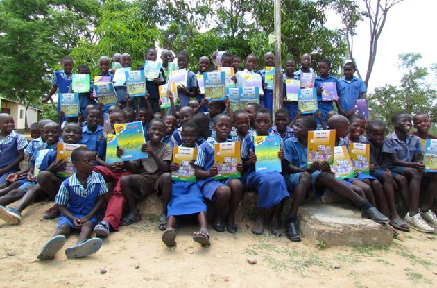 Pupils show their books after the handover of books by the Zimbabwe School Library trust in Chitomborwizi recently