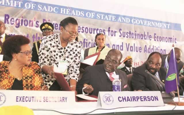 President Mugabe assuming the Sadc chair while flanked by Foreign Affairs Minister and chairperson of the Sadc Council of Ministers Simbarashe Mumbengegwi and Sadc Executive Secretary Dr Stergomena Lawrence Tax in Victoria Falls recently.