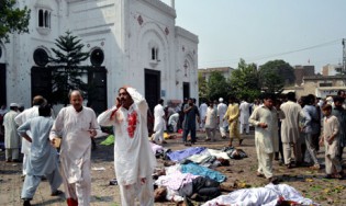People gather next to victims of a suicide attack on a church in Peshawar, Pakistan, Sunday, Sept. 22, 2013. (AP Photo)