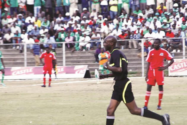 THE STONE AGE WORLD OF JUJU . . . This collage of pictures shows Buffaloes players (left) sitting on the touchline instead of the bench after the CAPS United players threw urine on their seats during half-time while (on the right) referee Darlington Shonhiwa takes away a bottle filled with urine which was thrown at the visitors' goal area by the home side's supporters during yesterday's Castle Lager Premiership soccer match at Gwanzura. (Pictures by Regis Nyandima)