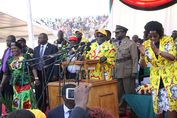 President Mugabe takes to the podium, while First Lady Amai Grace Mugabe (right) and Minister of State for Manicaland Provincial Affairs Mandi Chimene (extreme left) cheer