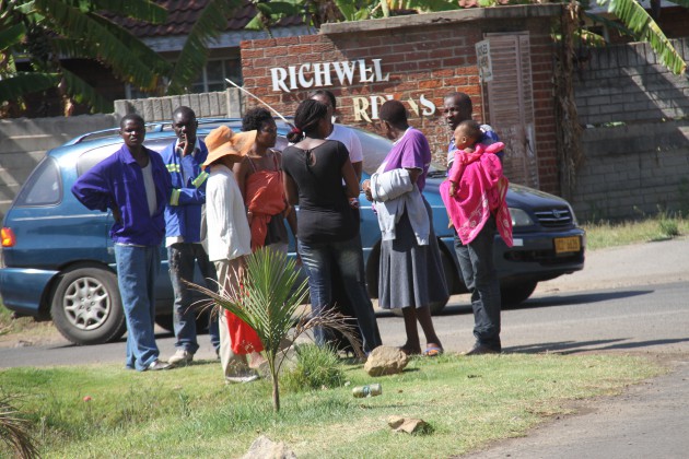 Residents watch from a distance as the children of the late had become violent