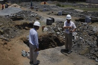 Chinese construction company site manager Mr Ma Xiang Fei (right) and agent manager Zhu Qi inspect progress of the new warehouse at Morton Jaffray Waterworks near Norton yesterday