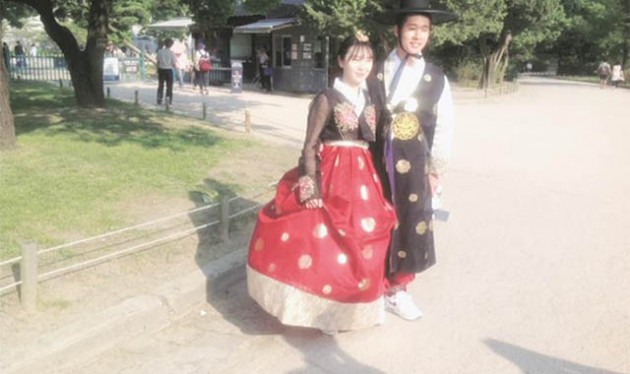 A young man and woman wearing Korean traditional designs Hanbok pose for a photo as they tour the Gyeongbok Palace (Northern Palace) in Seoul. — (Pictures by Tendai Manzvanzvike)