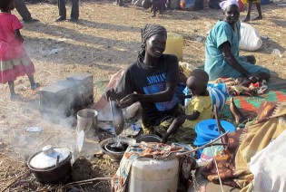 A handout photo released by the UNMISS shows displaced people sitting on Sunday. The United Nations said it would send more peacekeepers to embattled towns in violence-wracked South Sudan and evacuate “non-critical” staff as fighting raged across the country. — AFP