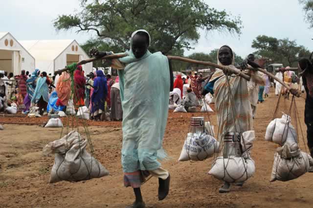 Women return to shelters after receiving food assistance provided by WFP at Yusuf Batil refugee Camp. - WFP/George Fominyen