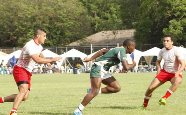 POWER PLAY . . . Cheetahs winger and top try scorer Tafadzwa Chitokwindo (centre) glides past two Tunisian players during yesterday's Confederation of African Cup Sevens Rugby tournament third-place play-off at Prince Edward High School in Harare. (Picture by Regis Nyandima)