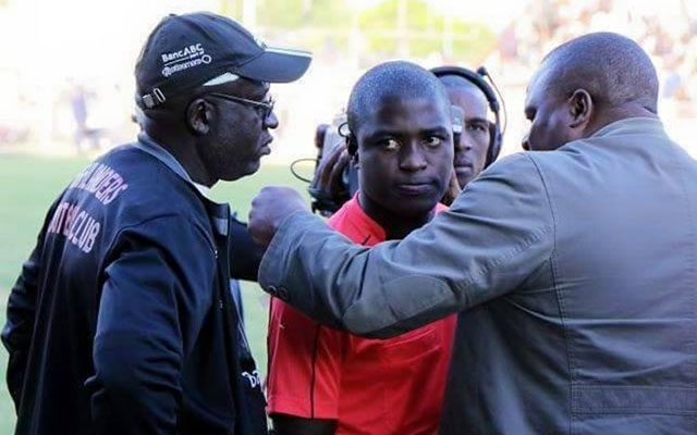 MAN IN THE MIDDLE . . . Assistant referee Thomas Kusosa (centre) is sandwiched by Highlanders’ acting chairman Modern Ngwenya (right) and assistant coach Amin Soma-Phiri at Barbourfields on Sunday