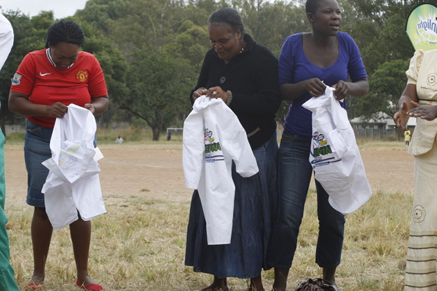 Jubilant women admire branded shirts they won after dancing for the crowd