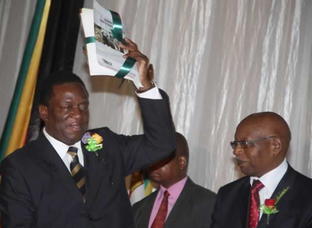 VP Mnangagwa raises the Zimbabwe National Competitiveness Report after its official launch in Harare yesterday, while ZNCR executive director Mr Norman Chakanetsa (right) looks on