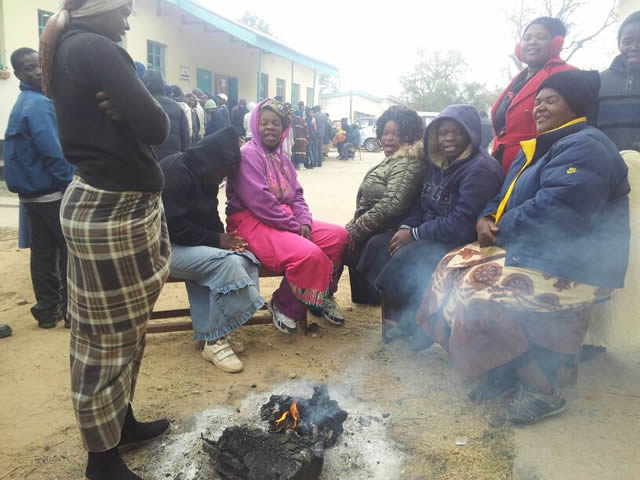 Voters brace the cold weather as they warm themselves waiting to cast their votes