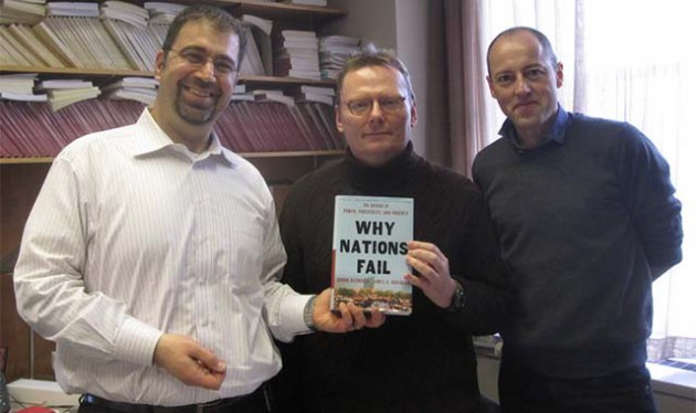 Daron Acemoğlu and James Robinson holding their best-selling book, “Why Nations Fail”