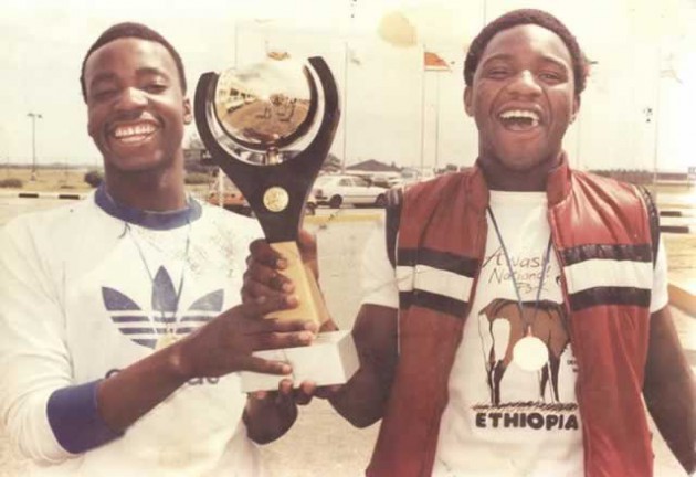 A GOLDEN DUO . . . The late Mercedes ”Rambo” Sibanda and Willard Mashikila-Khumalo pose with the CECAFA Under-20 trophy which Zimbabwe won in the ‘80s when they were part of a generation of Young Warriors who represented the country with distinction. — (Picture by Futbol News)