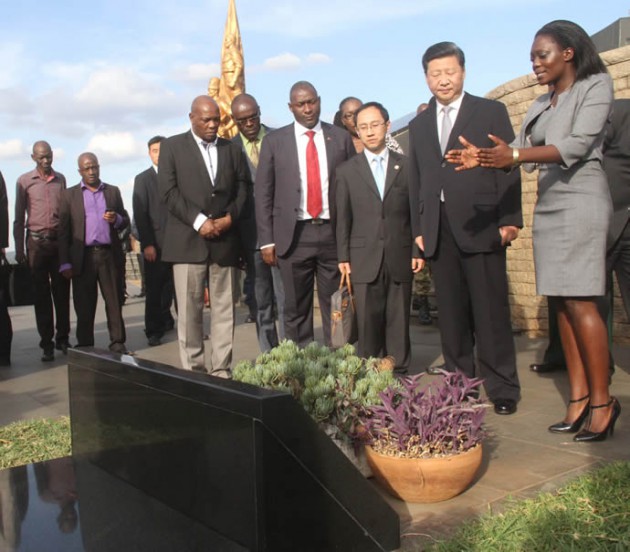 National Heroes Acre Resident Curator Rumbidzai Bvira shows President Xi the grave of liberation hero Herbert Chitepo while ICT Minister Supa Mandiwanzira (red tie) and ZTA chief executive Karikoga Kaseke look on.