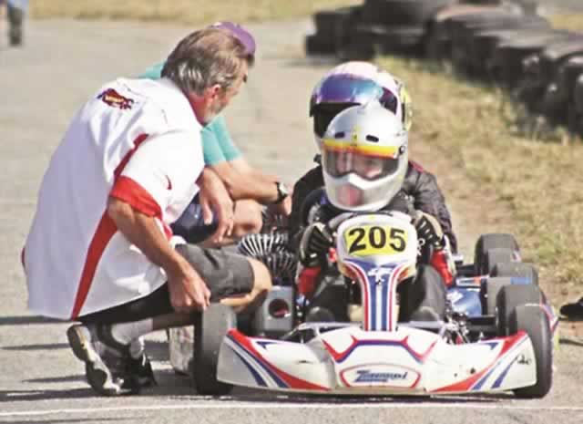FLAG BEARER . . . Young Zimbabwean karting driver Zac Dufty (second from right) proudly lifts his country’s flag high during the drivers’ parade at the start of last year’s ROK Cup International Finals in Italy. Dufty is set to compete at the same event next month