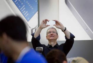 Tim Cook, chief executive officer of Apple Inc, takes a photograph during the launch of the iPhone 5c and 5s at the company’s new store in Palo Alto, California, recently. - Bloomberg