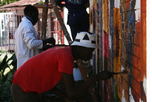 Art students work on a mural at the Hivos country office in Harare