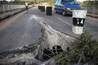 This picture combo shows (a) the Chivake Bridge that was damaged by a granite rock which fell off a moving haulage truck along the Harare-Nyamapanda Road in Murehwa yesterday, (b) the haulage truck after it hit trees on the side of the road and (c) Ministry of Transport and Infrastructural Development workers painting the granite block to alert motorists. - (Pictures by Justin Mutenda)