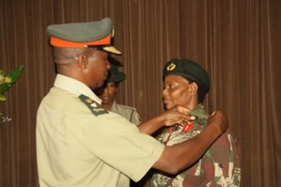 Zimbabwe National Army commander Lt General Philip Valerio Sibanda confers the first woman Shylet Moyo to the rank of a Brigadier General in Harare yesterday