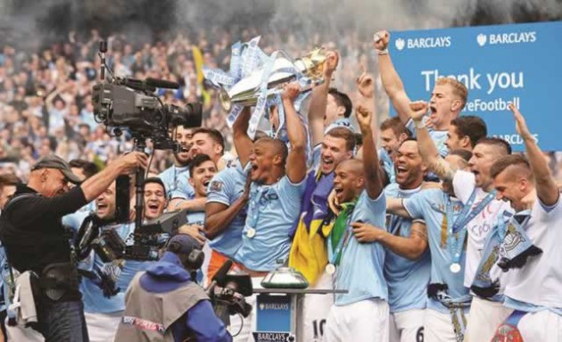 TOP OF THE TREE . . . Manchester City captain Vincent Kompany parades the Barclays English Premier League trophy in front of the Man City faithful at the Etihad Stadium yesterday. — Mailonline