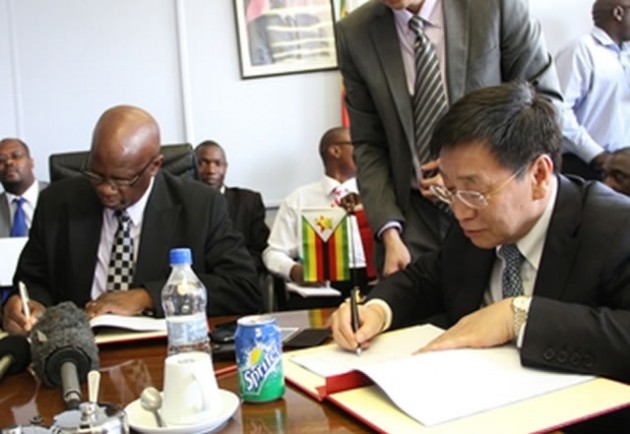 Finance Minister Patrick Chinamasa and China Exim Bank vice president Mr Zhu Hongjie sign the funding agreement at the New Government Complex in Harare yesterday