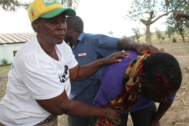 THE UGLY . . . A Zanu-PF supporter and victim of political violence is assisted by colleagues as blood flows from a gash on his head in Mhangura