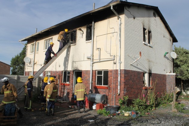 Members of the fire brigade retrieve the charred bodies from the main bedroom on the first.