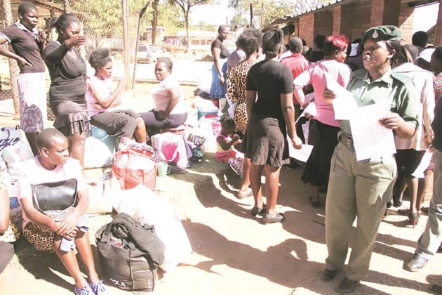 Zimbabwe Prisons and Correctional Service officer (in uniform) calls out names of inmates who were released at Chikurubi Female Prison in Harare yesterday. — (Picture by Justin Mutenda)