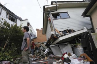 A devasted man looks at the rubble of what was once home-EPA/KIMIMASA MAYAMA