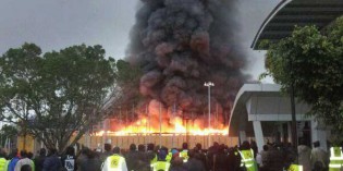 JKIA workers look at fire that engulfed the airport's arrival terminal (Photo: Courtesy @renjiSAN)