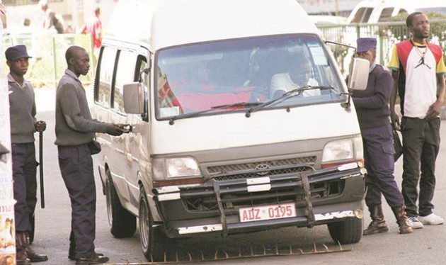 Police officers use a spike to stop a commuter omnibus that was picking passengers from an undesignated point along Jason Moyo Avenue in Harare yesterday. — (Picture by John Manzongo)