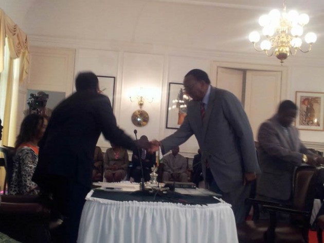 Joseph Made is congratulated by President Mugabe after signing his papers 