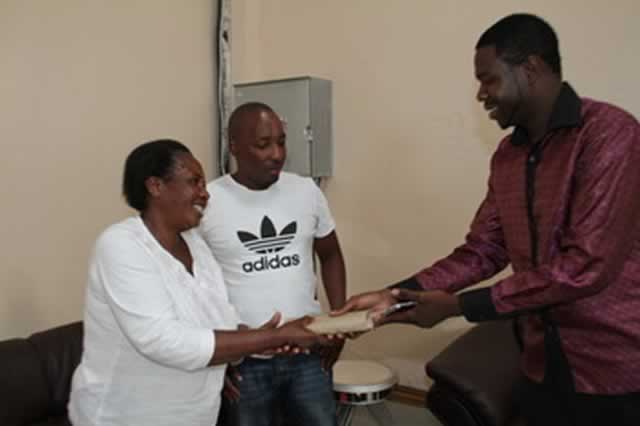PHD Ministries leader Prophet Walter Magaya hands over an envelope containing US$18 000 to Pretty Xaba’s sister-in-law Ruth Xaba and her son Peter at his church in Waterfalls yesterday. — Picture by John Manzongo
