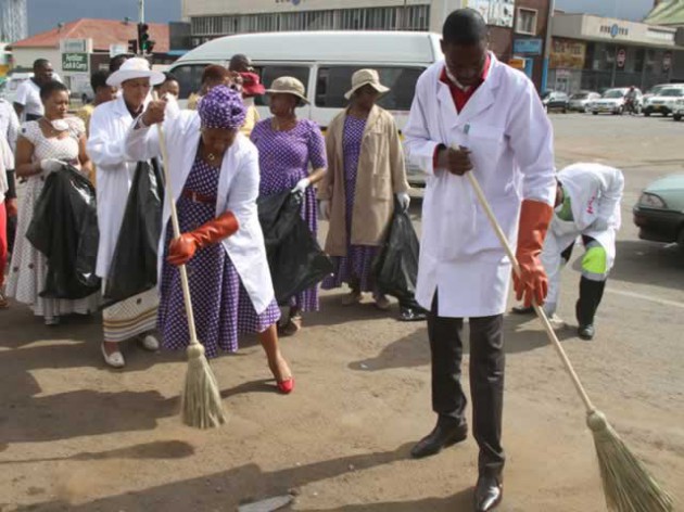 Prophet Emmanuel Makandiwa and his wife Prophetess Ruth Makandiwa sweeping during a clean-up campaign along Simon Muzenda Street in Harare yesterday