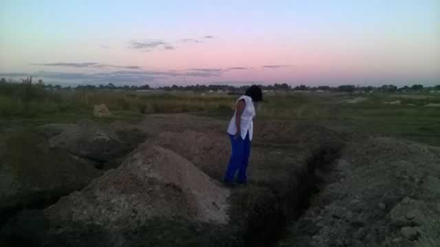 Above, Engineer Joy Makumbe inspects the foundation of a house to be constructed by her company