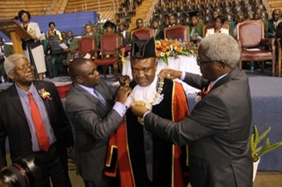 Local Government, Public Works and National Housing Minister Ignatius Chombo confers the newly-sworn in Harare Mayor Bernard Manyenyeni with the mayoral regalia at his inauguration in Harare yesterday while outgoing Mayor Muchadeyi Masunda looks on
