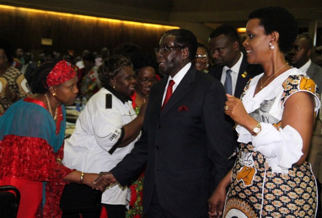 President Mugabe shakes hands with Central Committee member Cde Oppah Muchinguri upon his arrival at Zanu-PF Headquarters in the company of First Lady Amai Grace Mugabe. Picture by John Manzongo