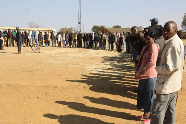 people queue to cast their votes at madamombe school in kadoma