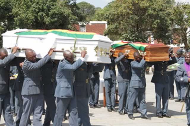 Air Force of Zimbabwe pall bearers carry caskets bearing the bodies of pilots Squadron Leader Taurai Jombo and Air Lieutenant Evidence Begede during a funeral parade at Manyame Airbase yesterday. - (Picture by John Manzongo)