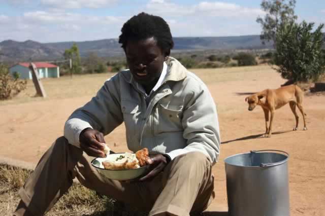 Michael Kamukondiwa, a polling agent, takes time off to have lunch at Musaringo Primary School in Makoni South.
