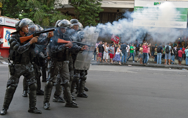 Members of the Special Police Operations Battalion (BOPE) launch tear gas in a bid to disperse protesters who entered the Central Train Station in Rio de Janeiro, Brazil on February 6, 2014. The protesters descended on the station to protest fare hikes for public transport.