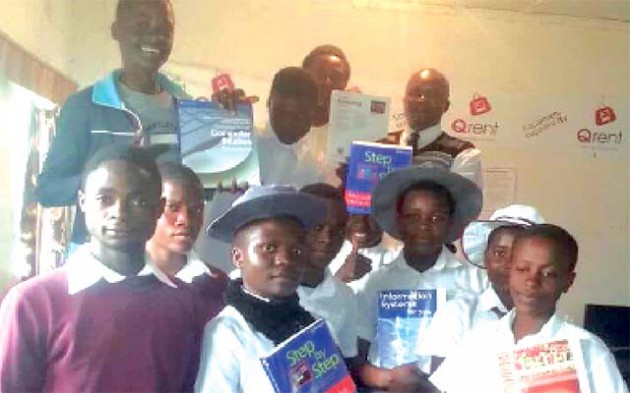 Students and head of ICT department with copies of donated books 