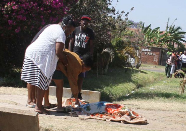 The daughter (in brown jacket) only identified as Victoria trying to have a look at the body with a relative